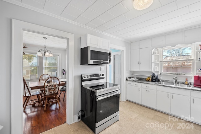 kitchen with sink, stainless steel appliances, decorative light fixtures, white cabinets, and light wood-type flooring