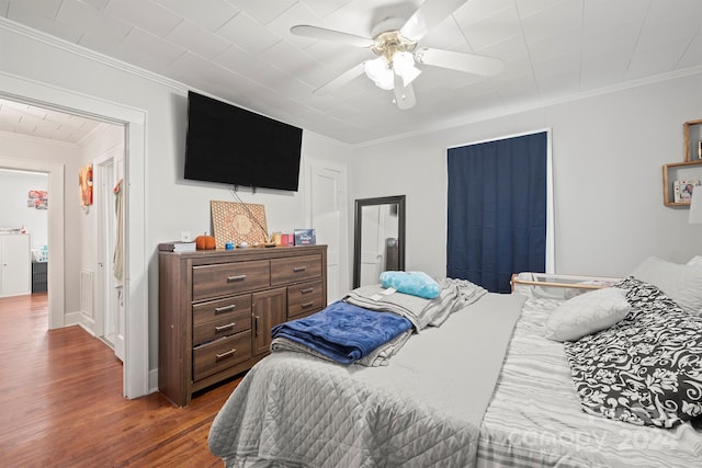 bedroom featuring ceiling fan, dark hardwood / wood-style flooring, and crown molding