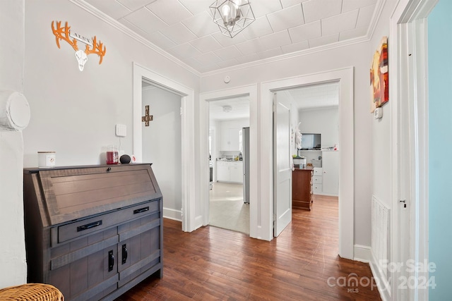 hallway featuring ornamental molding and dark wood-type flooring