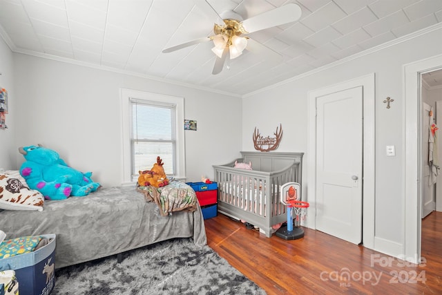 bedroom with ceiling fan, dark hardwood / wood-style flooring, and crown molding