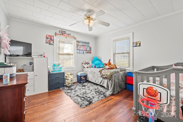 bedroom with multiple windows, ceiling fan, wood-type flooring, and ornamental molding