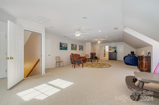 living area featuring light carpet, vaulted ceiling, and ceiling fan