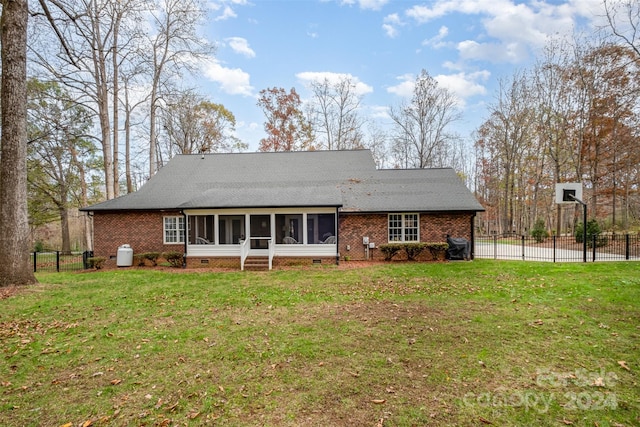 back of house featuring a yard and a sunroom