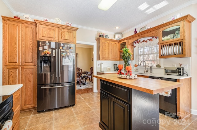 kitchen with black appliances, sink, ornamental molding, a textured ceiling, and butcher block counters