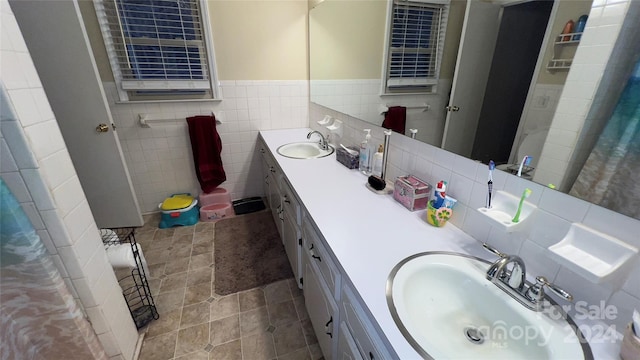 bathroom featuring tile patterned flooring, vanity, and tile walls