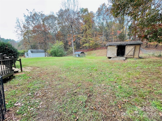 view of yard with a wooden deck and a storage shed