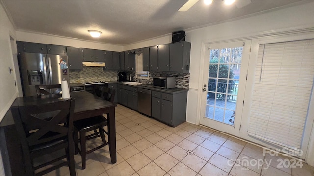 kitchen featuring light tile patterned floors, backsplash, stainless steel appliances, and ornamental molding