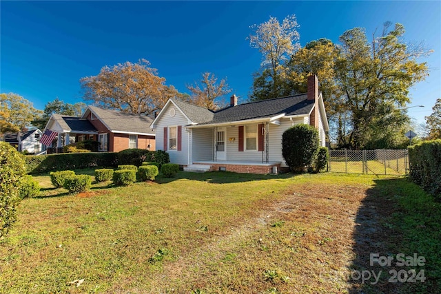 ranch-style house with covered porch and a front lawn