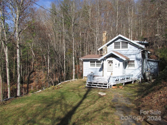 view of front of home featuring a wooden deck and a front yard