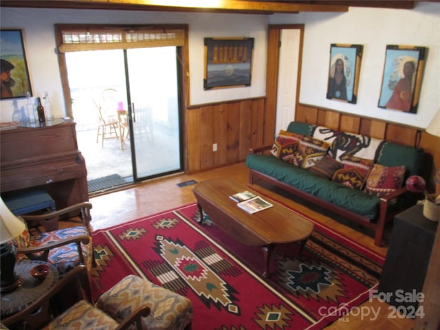 living room featuring hardwood / wood-style floors and wooden walls