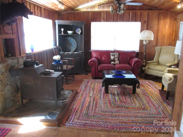 living room featuring wooden walls, a healthy amount of sunlight, and vaulted ceiling