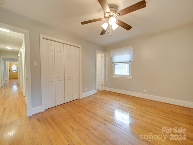 unfurnished bedroom with ceiling fan, light hardwood / wood-style floors, and a closet