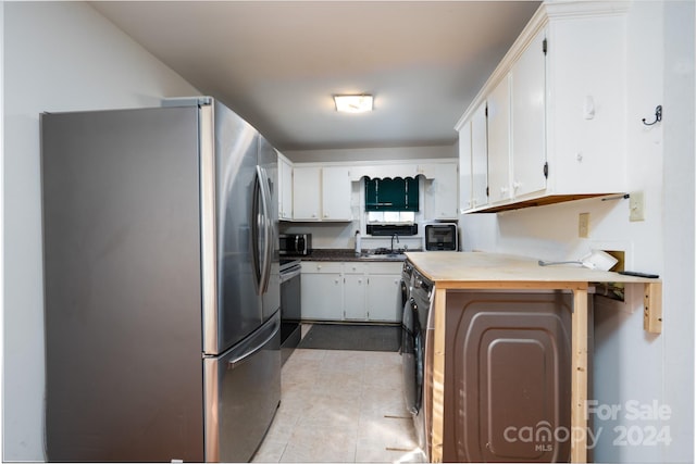 kitchen with kitchen peninsula, white cabinets, stainless steel appliances, and light tile patterned floors