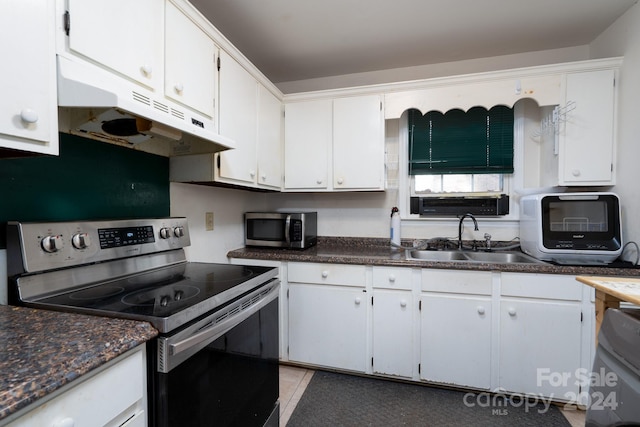 kitchen featuring white cabinetry, sink, light tile patterned floors, and stainless steel appliances