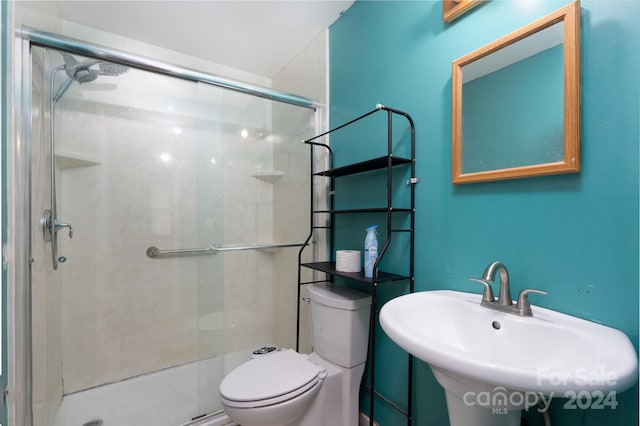 bathroom with sink, an enclosed shower, and toilet