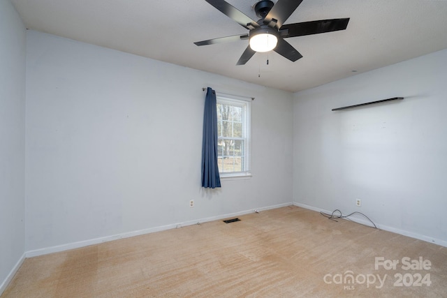 unfurnished room featuring light colored carpet and ceiling fan