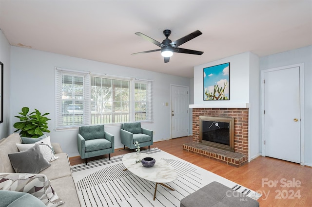 living room with ceiling fan, a fireplace, and light hardwood / wood-style floors