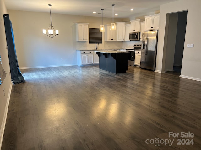 kitchen featuring white cabinets, a center island, stainless steel appliances, and hanging light fixtures