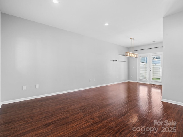 empty room featuring recessed lighting, baseboards, and wood finished floors