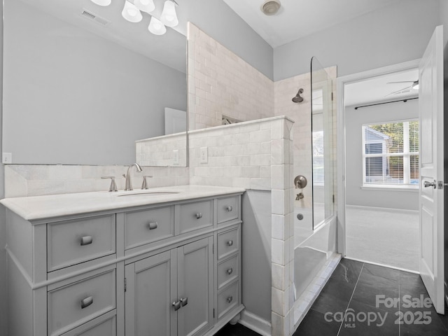 bathroom featuring visible vents, tub / shower combination, and vanity