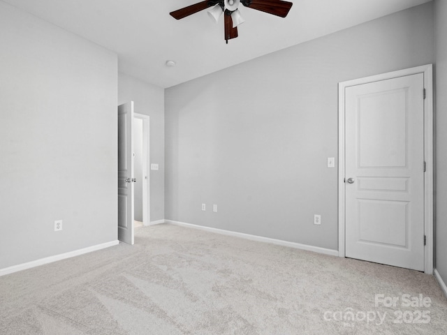 unfurnished room featuring baseboards, light carpet, and ceiling fan