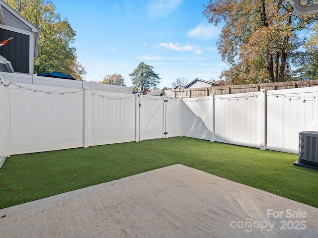 view of yard with a patio, a gate, a fenced backyard, and cooling unit