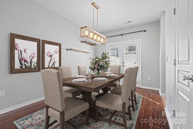 dining space with visible vents, baseboards, and wood finished floors