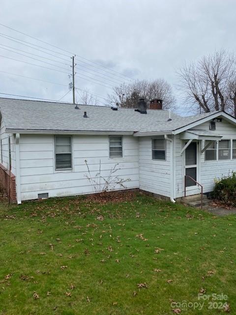 rear view of house with a lawn and a sunroom