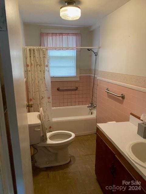 full bathroom with tile patterned floors, toilet, shower / tub combo with curtain, vanity, and tile walls