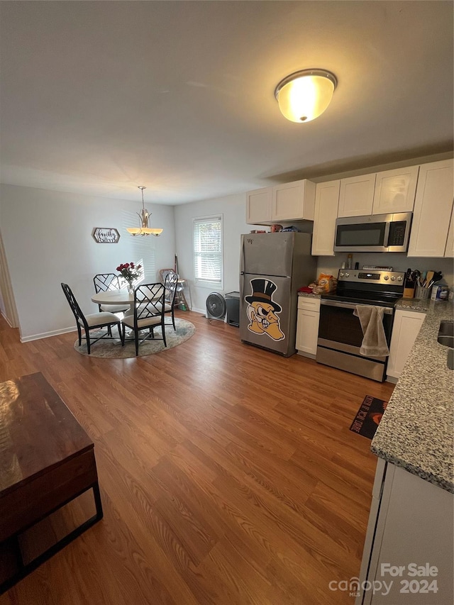 kitchen with appliances with stainless steel finishes, light hardwood / wood-style floors, and white cabinetry