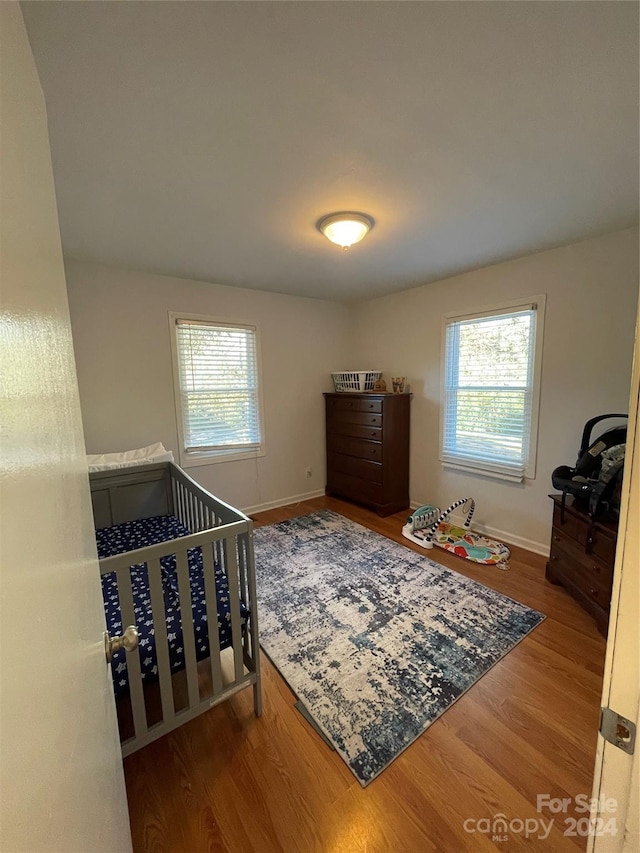 bedroom with hardwood / wood-style flooring and multiple windows