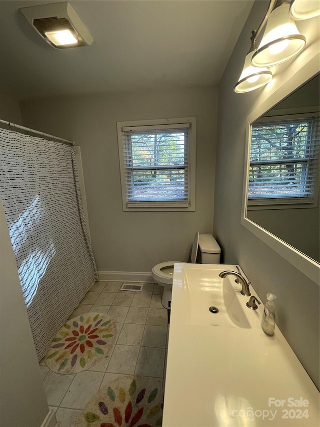 bathroom with tile patterned floors, a shower with curtain, toilet, and vanity