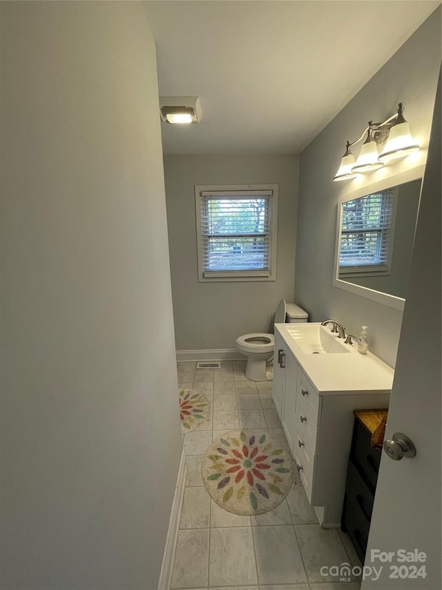 bathroom featuring tile patterned floors, vanity, and toilet