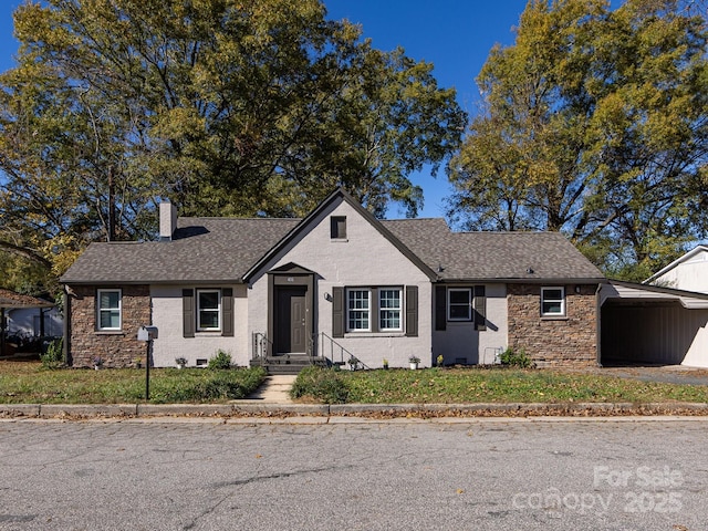 single story home featuring a front lawn and a carport