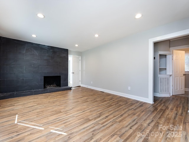 unfurnished living room with a fireplace and hardwood / wood-style flooring