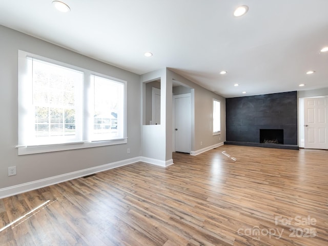 unfurnished living room featuring a fireplace and light hardwood / wood-style floors