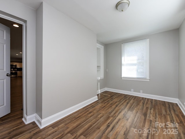 unfurnished room featuring dark wood-type flooring