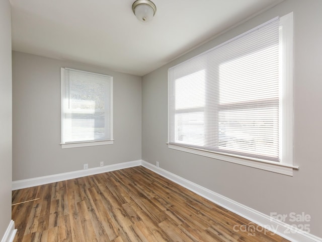 unfurnished room with dark hardwood / wood-style flooring and a healthy amount of sunlight