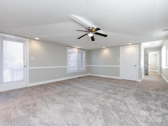 spare room with light carpet, vaulted ceiling, and ceiling fan