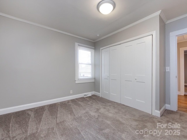 unfurnished bedroom with light colored carpet, a closet, and crown molding