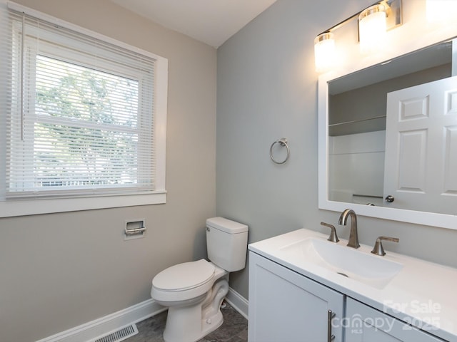 bathroom with toilet, vanity, and walk in shower