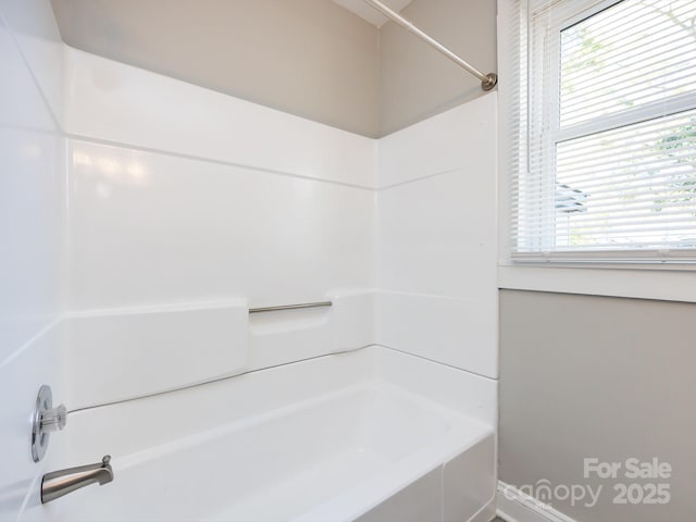 bathroom featuring a healthy amount of sunlight and tiled shower / bath combo