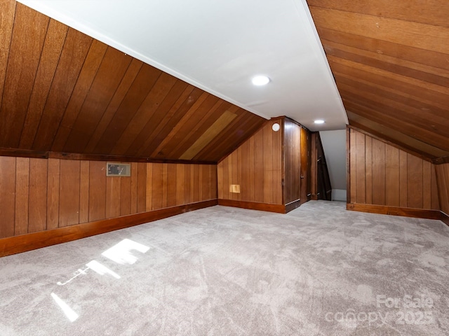 additional living space featuring wood walls, wooden ceiling, light carpet, and vaulted ceiling