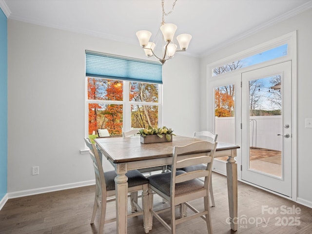 dining space featuring hardwood / wood-style floors, ornamental molding, and a chandelier