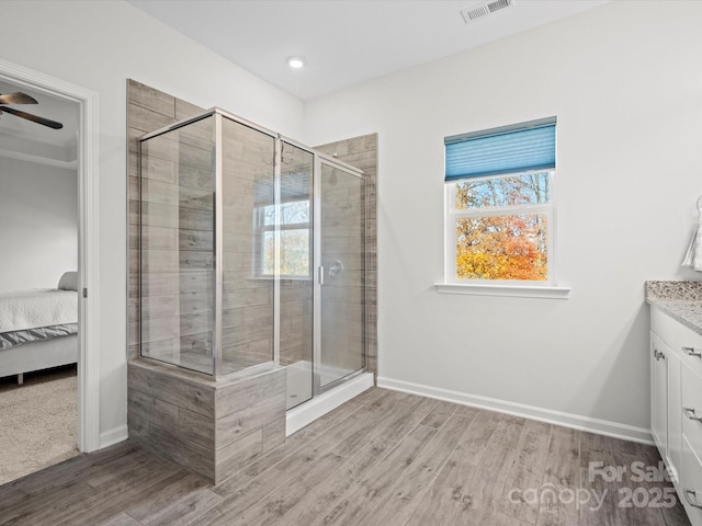 bathroom with wood-type flooring, vanity, and walk in shower