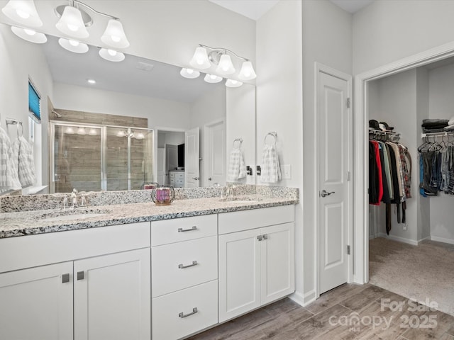 bathroom with vanity, a shower with shower door, and hardwood / wood-style floors