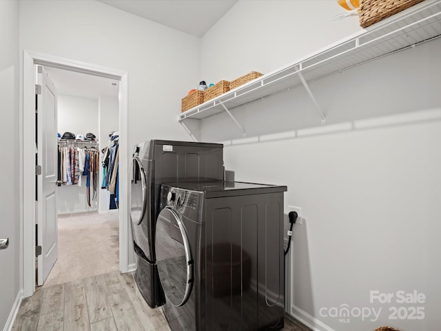 laundry room featuring washing machine and dryer and light wood-type flooring