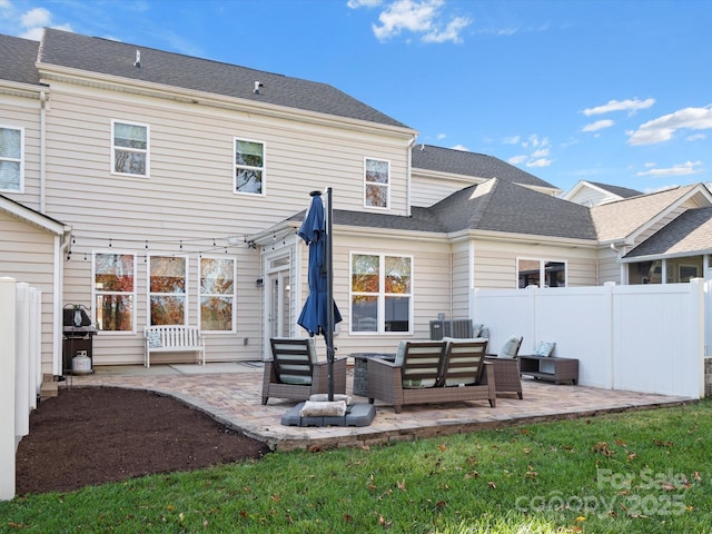 rear view of house with an outdoor living space, a yard, and a patio area