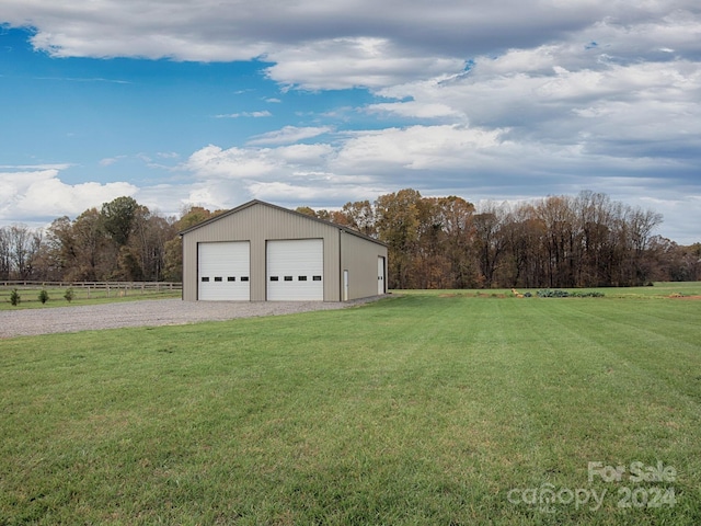 view of yard featuring a garage and an outbuilding