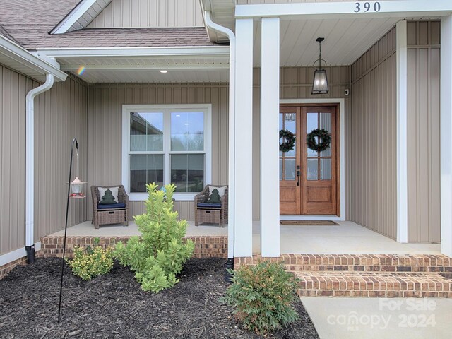 entrance to property featuring covered porch and french doors